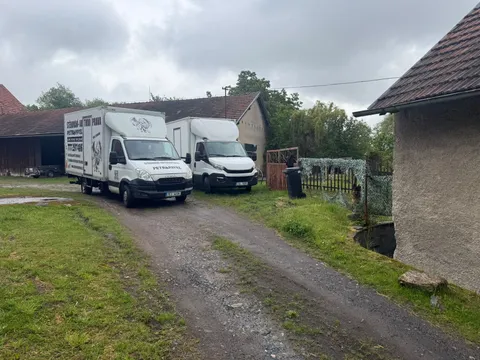 Dva stěhovací vozy na příjezdové cestě