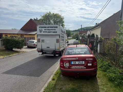 Stěhovací vůz zaparkovaný mezi auty v ulici