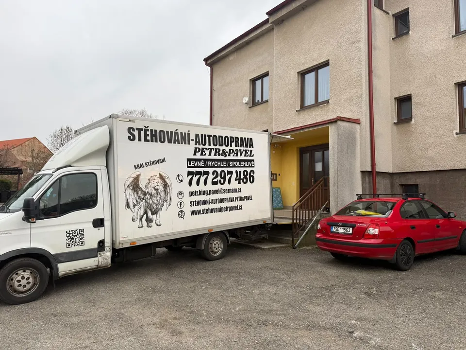 Stěhovací vůz Petr & Pavel přistavený u rodinného domu, stěhování v Kolíně